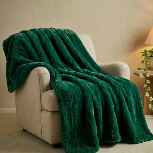 Green cozy soft furry faux-fur blanket draped over a beige armchair in a cozy living room setting. Luna's Blanket Pine